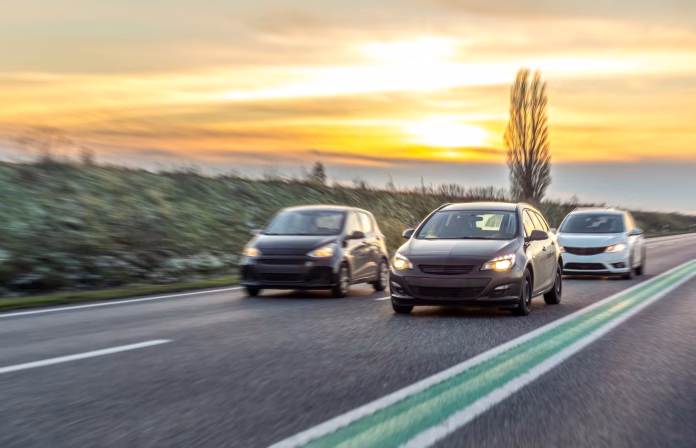 cars-stream-along-highway-sunset-glow-evening-traffic Carbon Neutral Passenger Cars - Can passenger cars become carbon neutral? Learn about the automotive industry's transformation towards cleaner mobility and sustainability