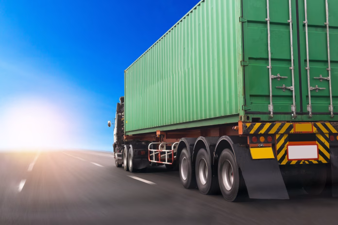 Truck on highway road with green container, transportation concept.,import,export logistic industrial Transporting Land transport on the asphalt expressway.with blue sky background Discover how Fleet Profitability starts with smarter tyre management, reducing costs, improving safety, and minimising vehicle downtime